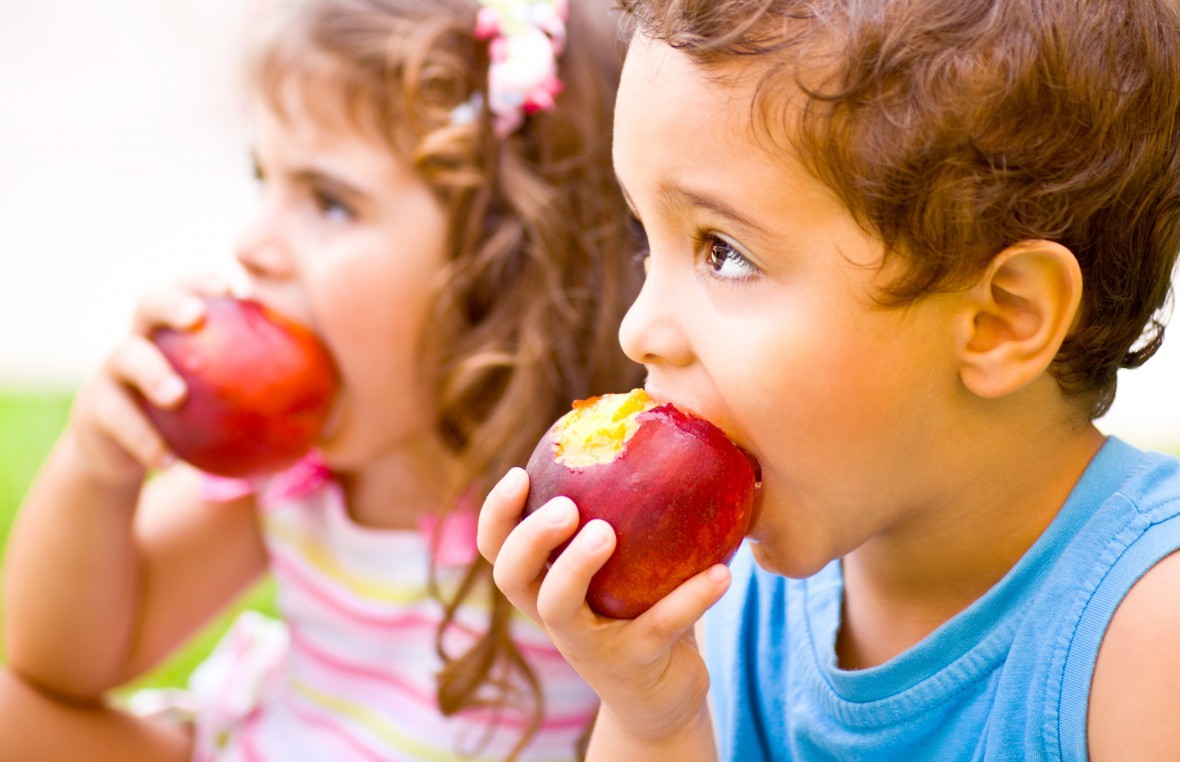 Дети на уроке едят яблоко
